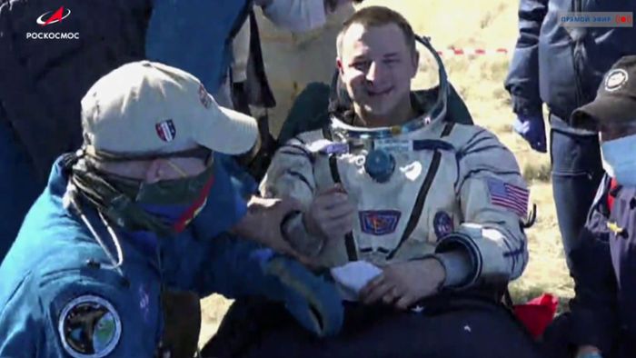 Raumfahrer nach Landung mit Mundschutz und Handschuhen empfangen