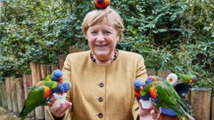 Angela Merkel zeigt sich als Papageienflüsterin