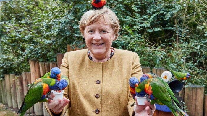 Angela Merkel zeigt sich als Papageienflüsterin