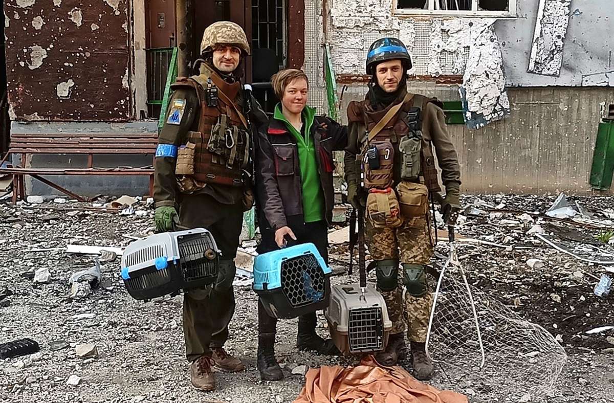 Auch beim Bergen von zurückgelassenen Tieren  helfen ukrainische Soldaten. Hier sind sie mit einer Helferin  von Animal Rescue Charkiw unterwegs. In den Boxen sind Katzen, die in dem zerstörten Gebäude zurückgeblieben sind.