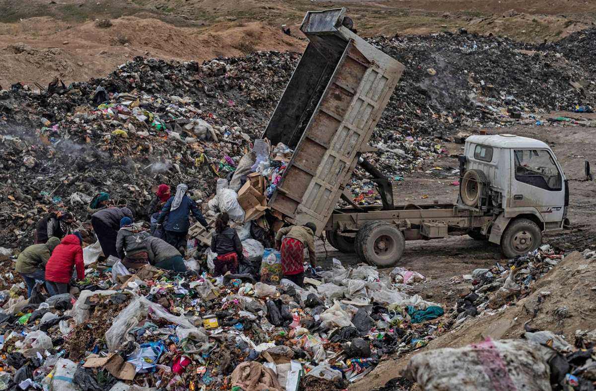 Im Nordosten von Syrien warten Menschen auf einer Müllkippe auf den neuen Müll. Sie hoffen auf Gegenstände die sie verkaufen, oder auch essen können.