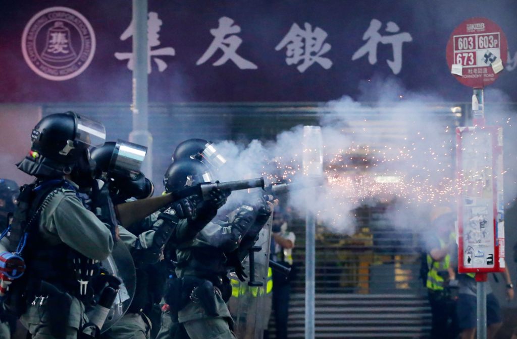 Polizisten mit Gasmasken schießen in Hongkong Tränengas auf Demonstranten. Foto: dpa