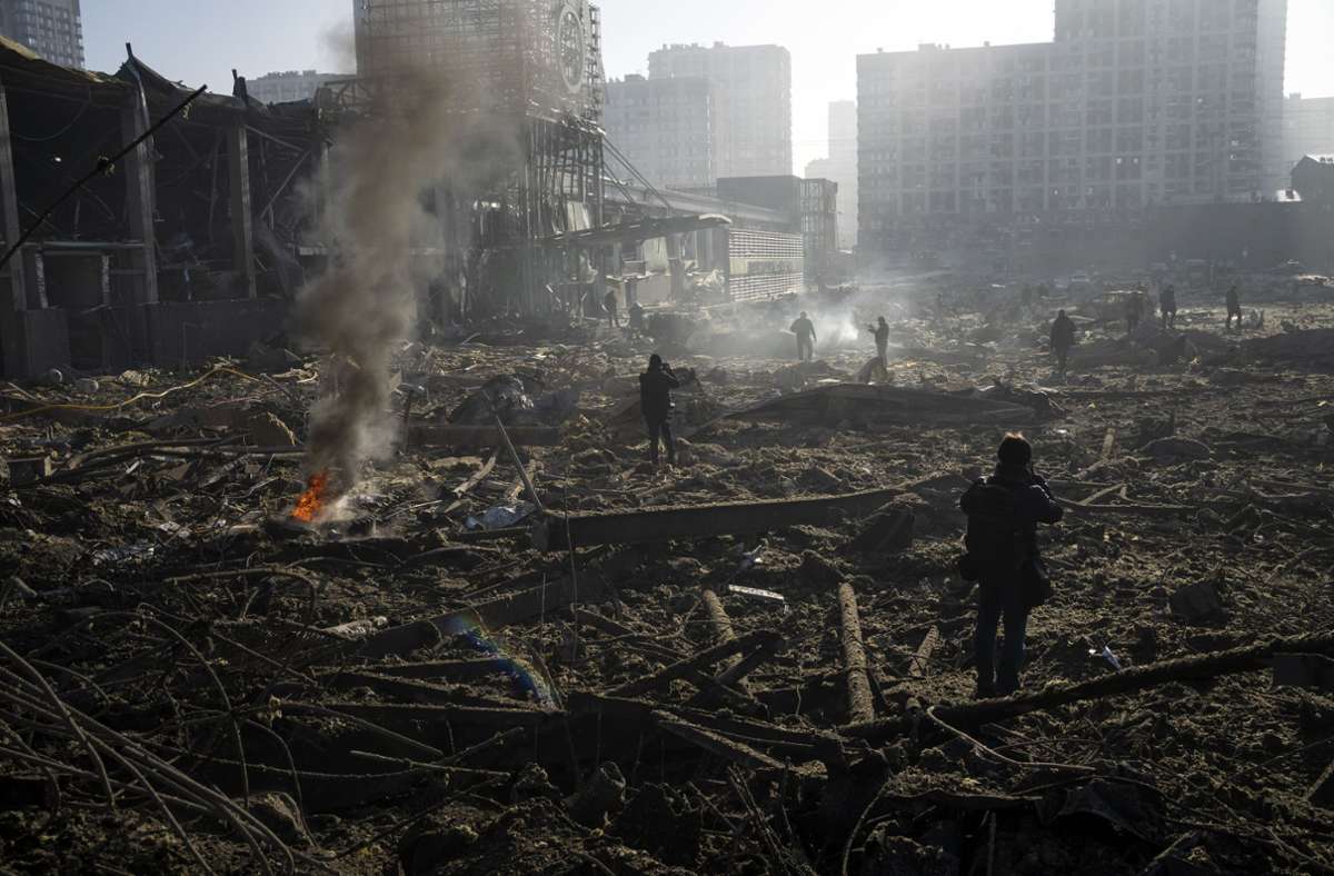 Menschen in Kiew, in den Trümmern eines Einkaufszentrums. Foto: dpa/Rodrigo Abd