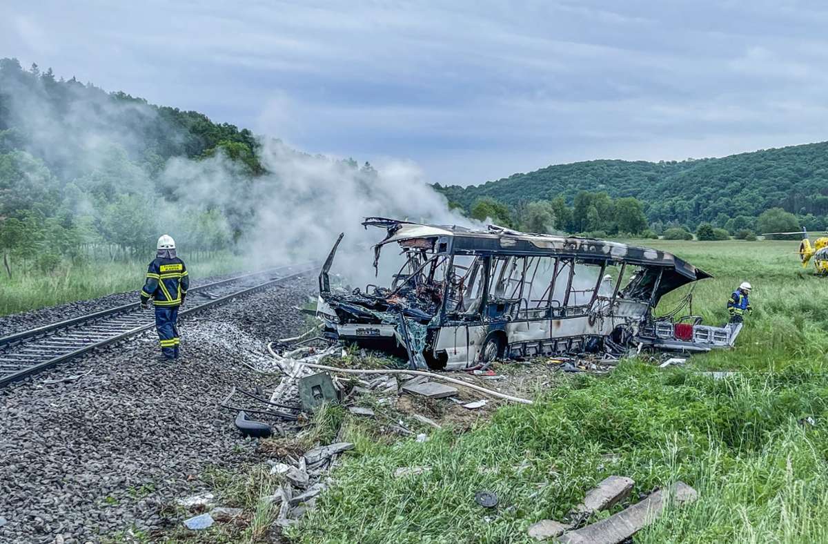 Die Feuerwehr löschte den Brand in einem Bus, der zuvor mit einem Zug kollidiert war.
