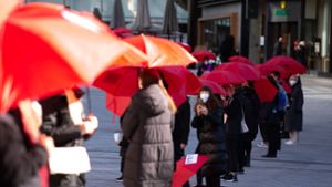 Protest gegen Femizide  unter blutroten Schirmen