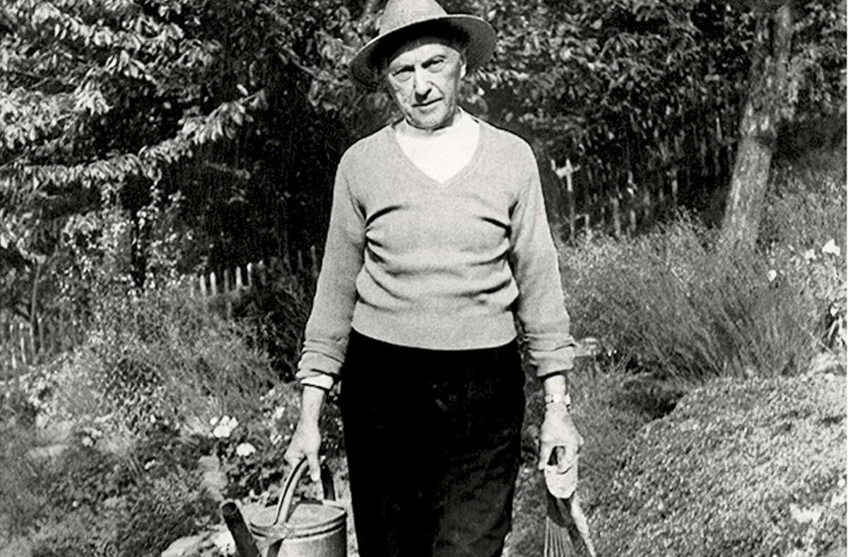 Konrad Adenauer mit Gießkanne und in Gartenkleidung.