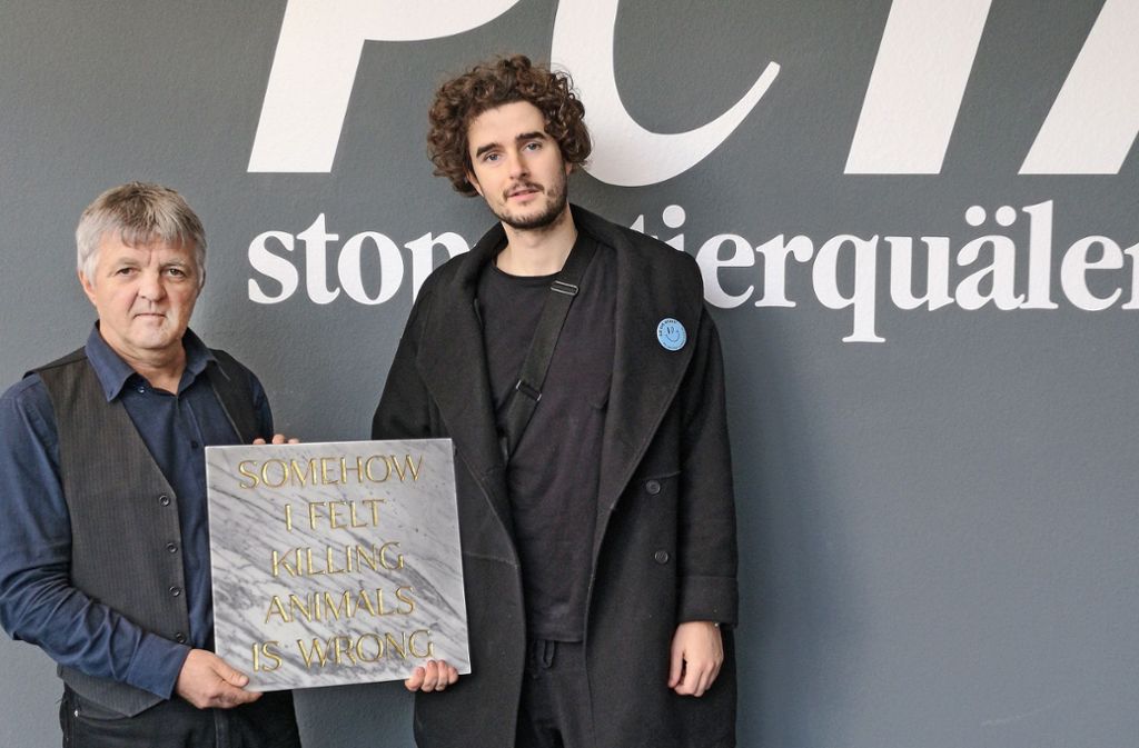 Der vegan lebende Künstler Tim Bengel (rechts)  hat dem Peta-Chef Harald  Ullmann eine Grabstein seiner Berliner Installation zum 25.  Geburtstag der Tierschutzorganisation geschenkt.