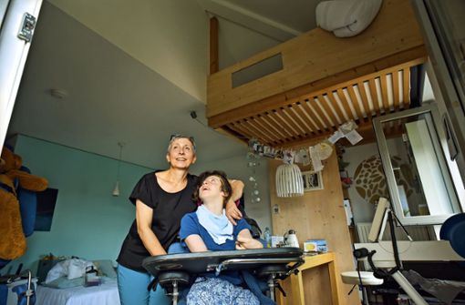 Pflege in einer angespannten Wohnsituation: Die Mutter von Emma, Christel Kress, schläft in einem Bett unter der Zimmerdecke. Foto: Lichtgut/Max Kovalenko