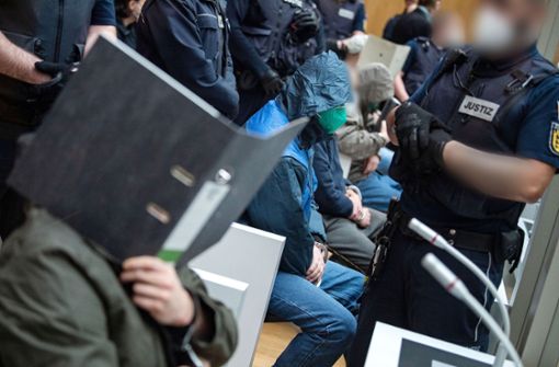 Einige Angeklagte sitzen kurz vor Beginn des Prozesses gegen die mutmaßlich rechtsterroristische Vereinigung „Gruppe S.“ in einem Saal im Oberlandesgericht Stuttgart-Stammheim. (Archivbild) Foto: dpa