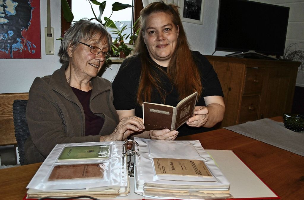 Helene Erhardts Tochter und Enkelin, Gertrud  und Stefanie Hauser, blättern in einem dicken Ordner voller Erinnerungen.