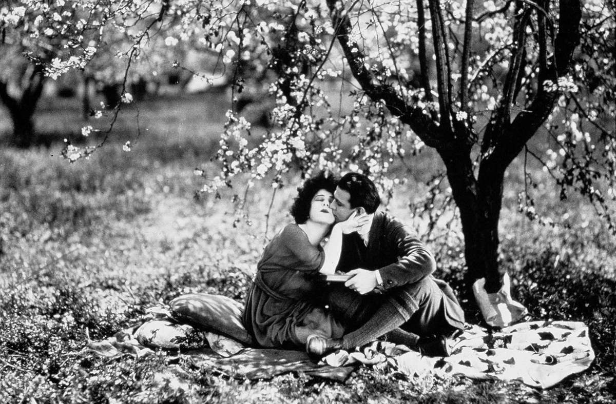 Schmusen unterm Baum: Alla Nazimova und Rudolph Valentino in dem  Film „Camille“ aus dem Jahr 1921 in der Regie von   Ray C. Smallwood.