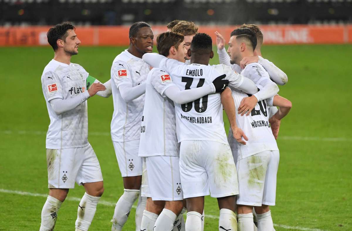 Die Profis von Borussia Mönchengladbach bejubeln ein Tor – unter ihnen ist ein Fan des KSC Foto: imago/Maik Hölter