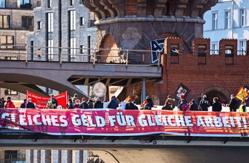 Metaller demonstrieren auf einer Brücke in Berlin für die Angleichung der Arbeitszeiten an den Westen. Foto: dpa/Christophe Gateau