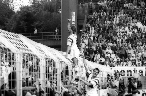 Auf dem Zaun stehend bejubelt Fritz Walter einen Treffer beim 3:0-Sieg. Manfred Schnalke sichert ab. Foto: imago/Sportfoto Rudel