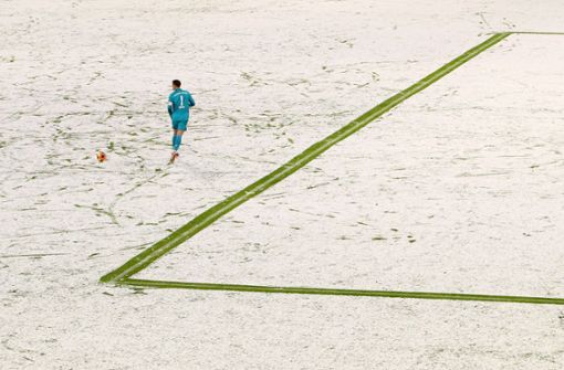 Bayern-Torwart Manuel Neuer allein  auf der weißen Pracht in der Allianz-Arena. Foto: dpa/Adam Pretty