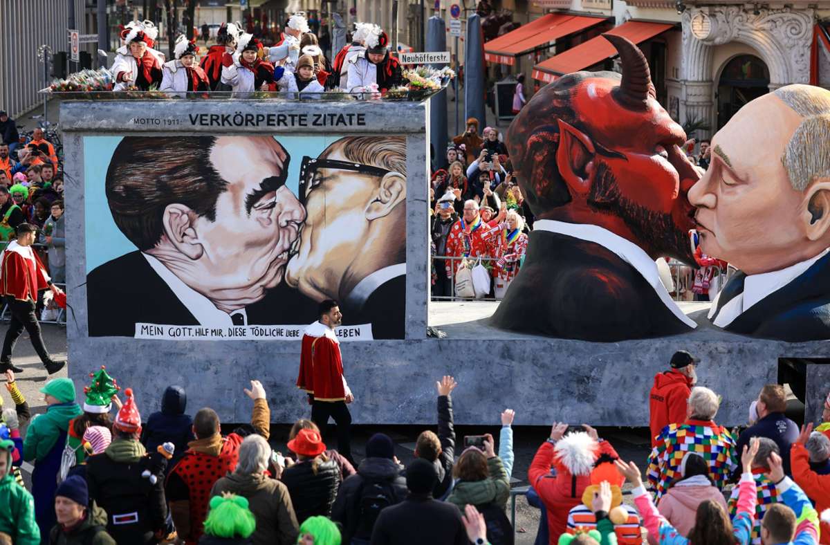 Der Mottowagen „Verkörperte Zitate“ mit einer Darstellung des russischen Präsidenten Putin der den Teufel küsst, fährt in Köln im Festumzug mit.