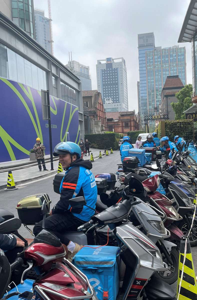 Die Mopedfahrer  in Firmenuniform warten auf den nächsten Auftrag.