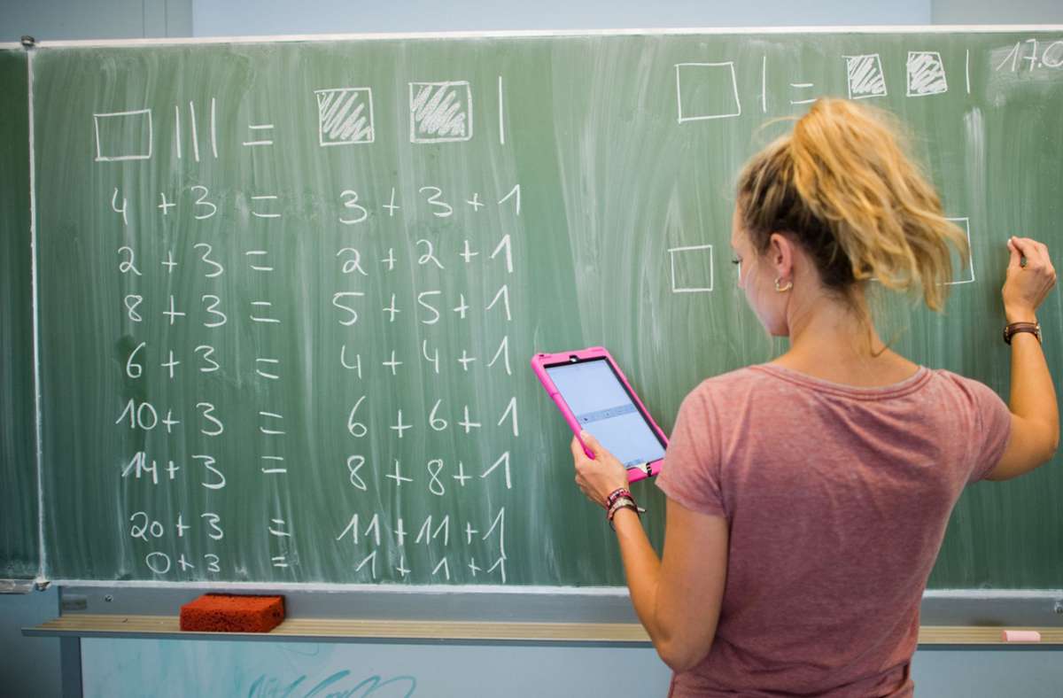 Schwamm, Kreide und Computer müssen sich im Unterricht nicht ausschließen. Diese  Mathelehrerin arbeitet mit Tafel und Tablet. Foto: dpa/Julian Stratenschulte