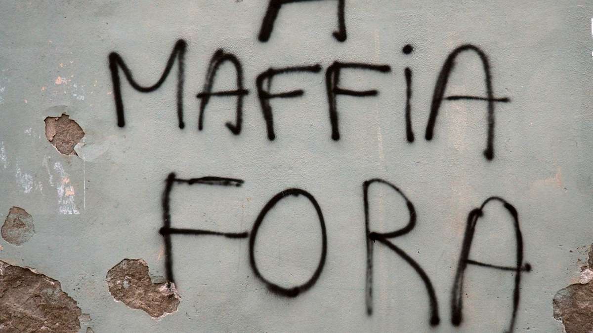 An eine Hausmauer in der korsischen Küstenstadt Bastia steht auf Korsisch geschrieben Mafia raus.
