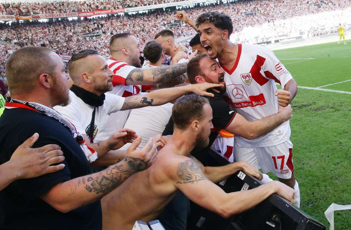 Omar Marmoush und andere VfB-Profis  feiern mit den Fans den Nichtabstieg auf dem letzten Drücker mit dem Sieg über den 1. FC Köln. Foto: Baumann/Hansjürgen Britsch