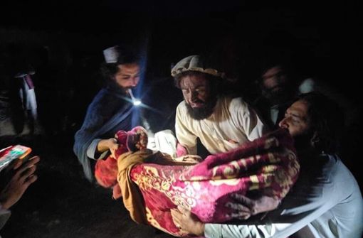 Afghanen bergen ein Opfer nach einem heftigen Erdbeben an der afghanisch-pakistanischen Grenzregion. Foto: dpa/Uncredited