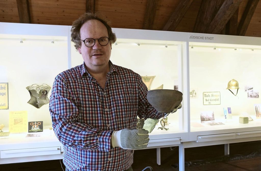 Matthias Busch von  Pro Alt-Cannstatt zeigt die Glasscherbe aus der Römerzeit und eine vollständig erhaltene Schüssel.