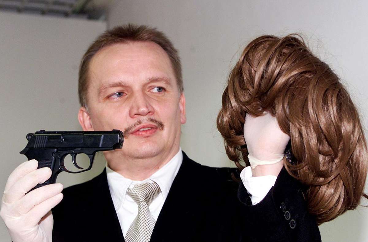 Der Ermittler zeigt eine Waffe und Frauenperücke der Serienbankräuber, die 2003 gefasst wurden. Foto: Kraufmann/Susanne Ker/n