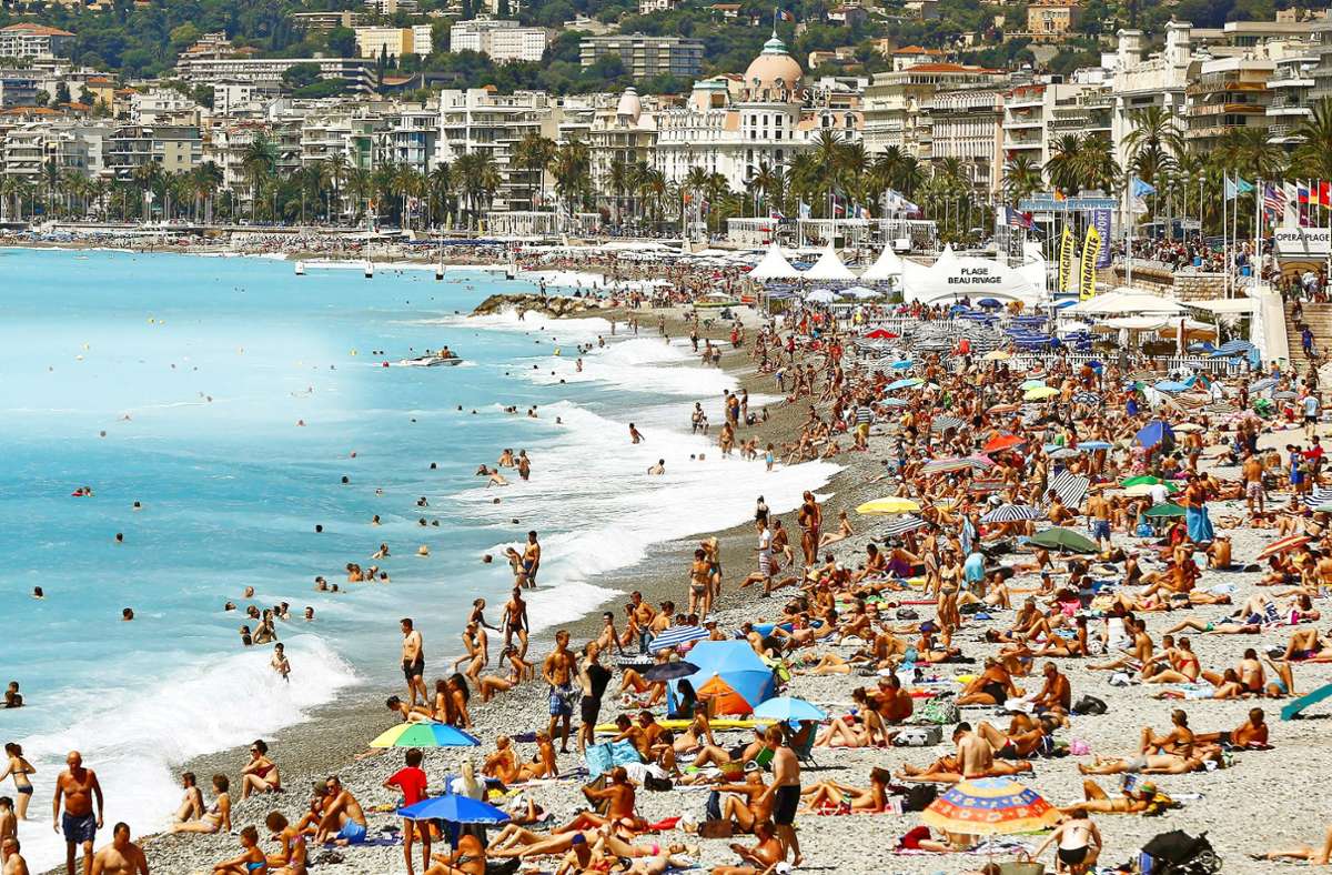 Menschen tummeln sich am überfüllten Strand der Promenade des Anglais in Nizza. Foto: dpa/Sebastien Nogier