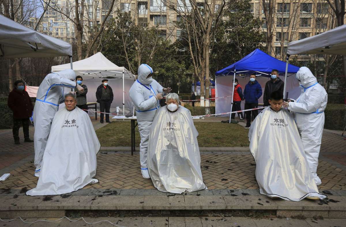 Die Angst vor der Omikron-Variante ist groß in China – gerade vor den Olympischen Winterspielen in Peking. Die Stadt Xi’an im Nordwesten befindet sich im Lockdown. Friseure in Schutzkleidung schneiden den Bewohnern im Freien die Haare.