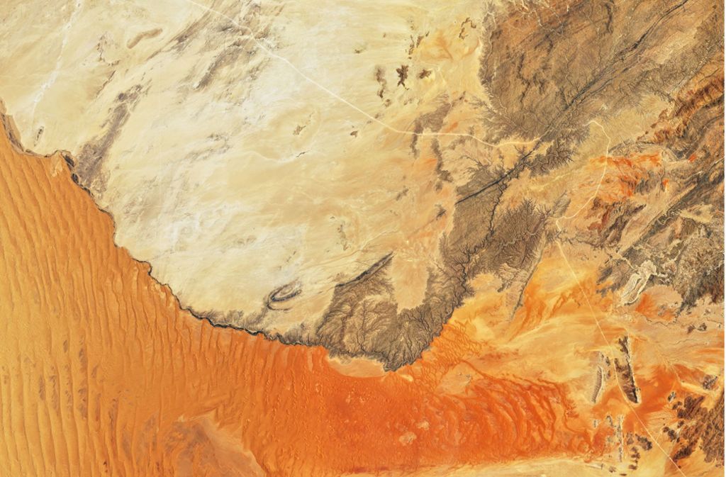 Die Namib-Wüste an der Südwestküste Afrikas: Die  bis zu 300 Meter hohen Sanddünen werden durch einen reißenden Fluss von einer Berglandschaft abgegrenzt. Das Bild ist vom 13. November 2019.