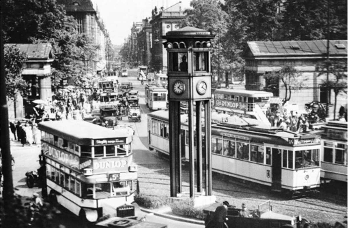 1924 wird auf dem Potsdamer Platz in Berlin eine automatische Ampel aufgestellt. Sie zeigt auch die Uhr an. Der Polizist oberhalb der Uhren überwacht den Verkehr und kann im Notfall eingreifen.