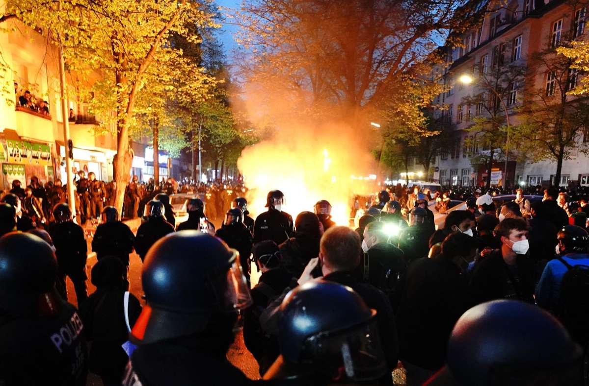 Polizisten stehen am Rande der Demonstration linker und linksradikaler Gruppen unter dem Motto „Demonstration zum revolutionären 1. Mai“ vor einem Feuer auf der Straße. Foto: dpa/Kay Nietfeld