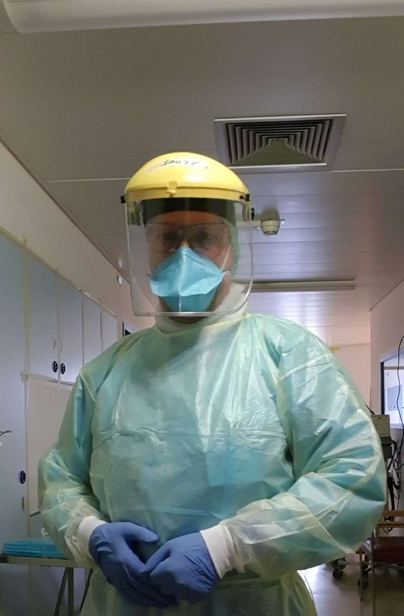 Andre Lindner  steckt in einem wasserundurchlässigen Ganzkörperanzug, trägt Handschuhe, Schutzbrille, eine FFP3-Maske und ein Visier vorm Gesicht. Dennoch steckt er sich am 31. Dezember 2020  mit dem Virus an.