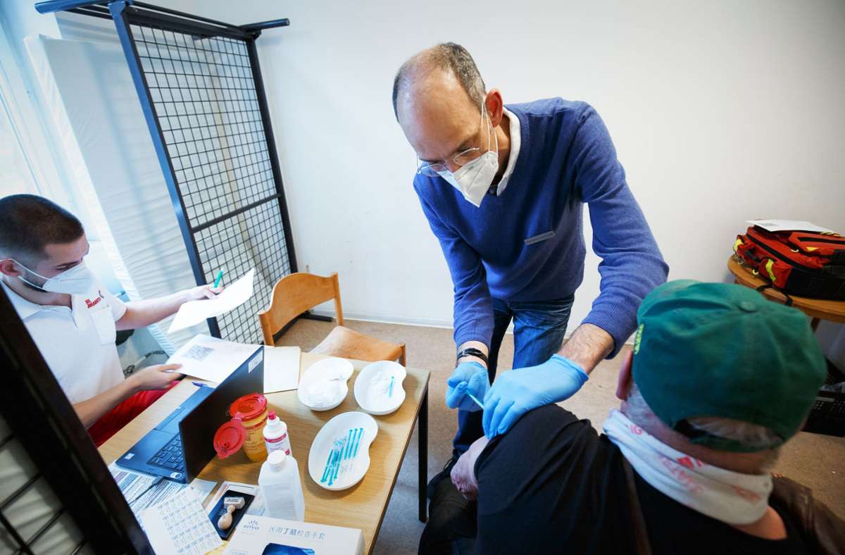 Der Hautarzt Ralf Denfeld setzt die Spritze bei einem Bewohner der Zentralen Notübernachtung. Foto: Lichtgut/Leif Piechowski