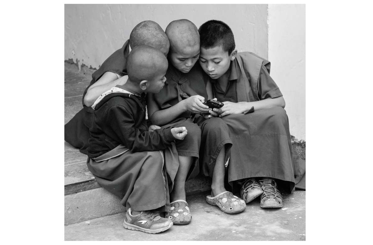 Verschlossene Welt? Diese jungen Buddhisten in Indien halten Kontakt per Handy.