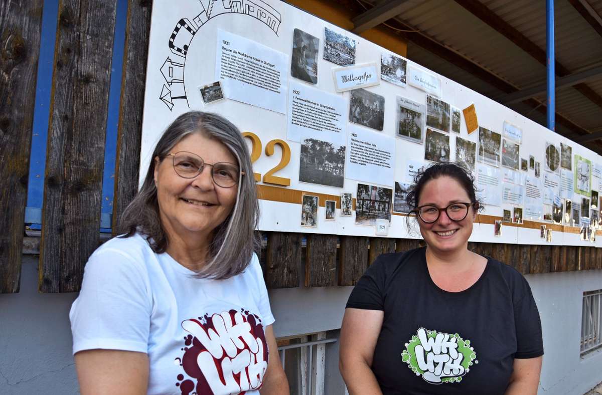 Andrea Krautwald (li.) und Waldheimleiterin Corina Berner präsentieren die Wand mit der hundertjährigen Geschichte des Ferienwaldheims Untertürkheim.