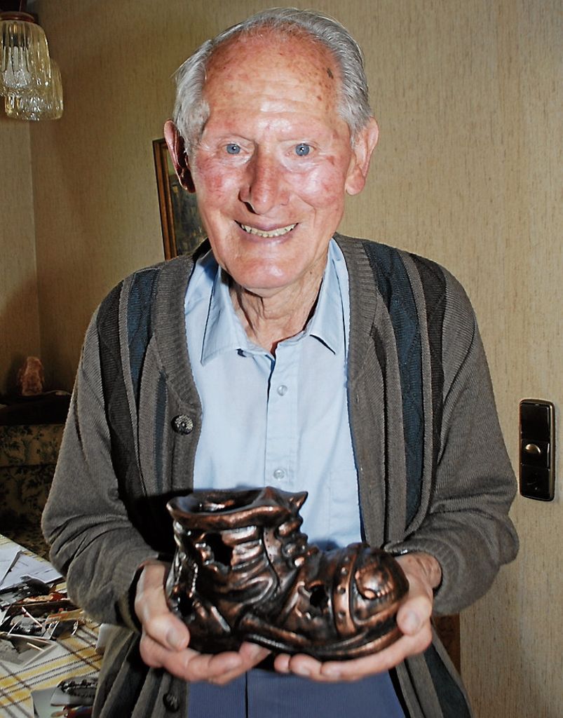Der 94-Jährige mit dem Abschiedsgeschenk der Kollegen: einem im Werk gegossenen Wanderschuh. Foto: Kuhn