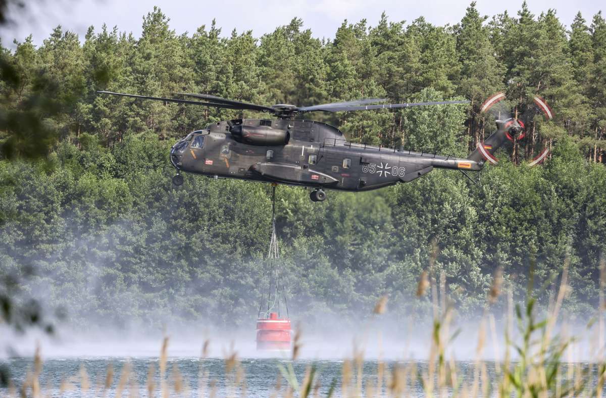 Ein Bundeswehrhubschrauber vom Typ Sikorsky CH-53 holt Löschwasser zur Waldbrandbekämpfung aus dem Kiebitzer Baggerteich nahe dem brandenburgischen Falkenberg.