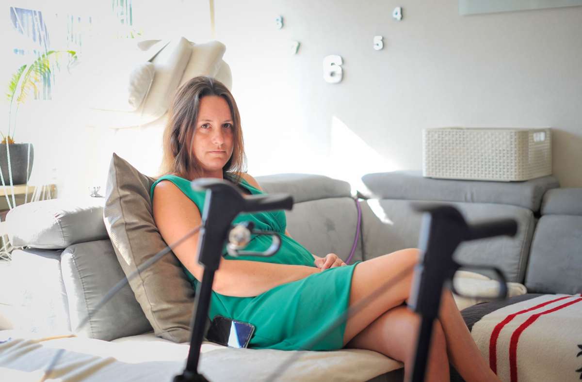 Nicole L. verbringt gezwungenermaßen den Großteil des Tages auf dem Sofa. Die Beine, die so lässig übereinandergeschlagen sind, tragen sie nicht mehr. Foto: Lichtgut/Max Kovalenko