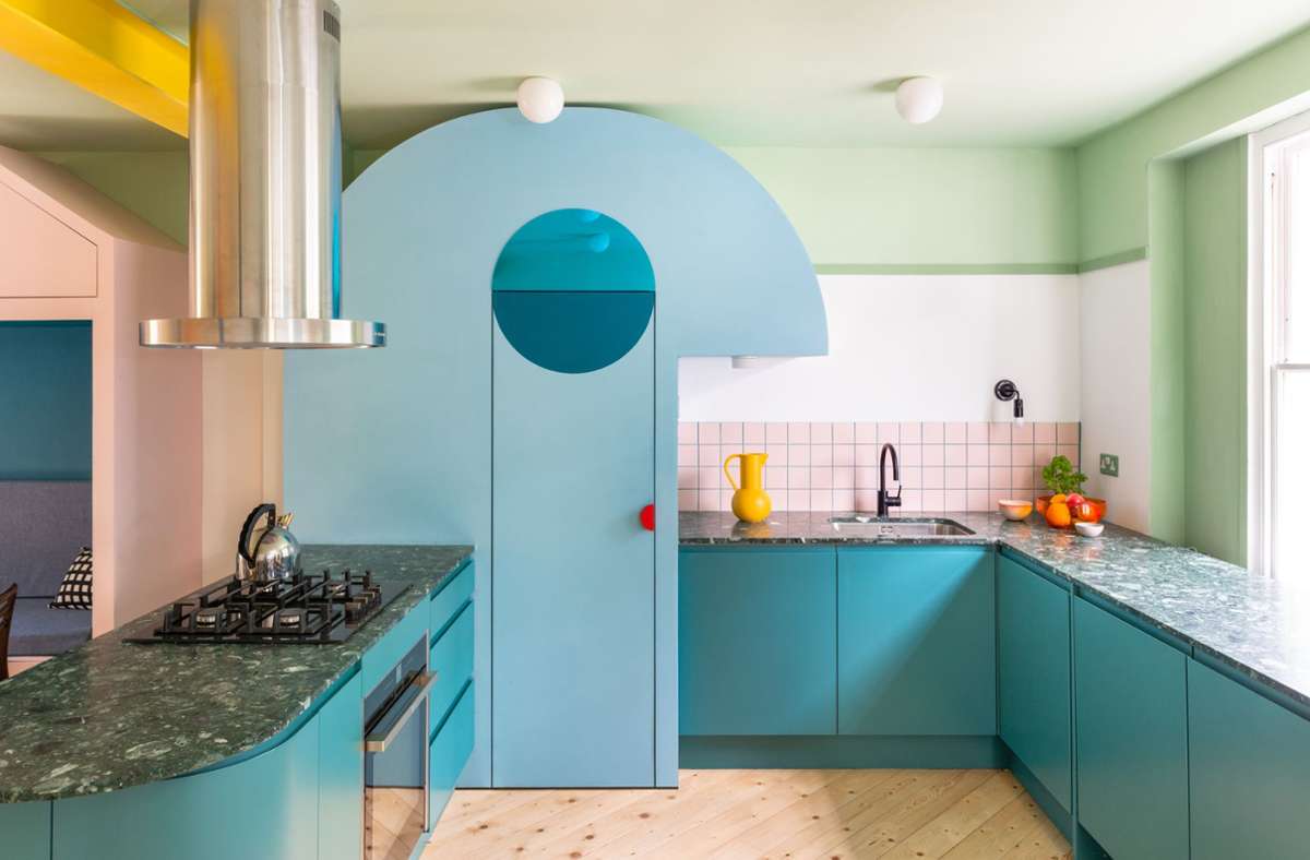 Küchen müssen nicht immer weiß sein! Blau- und Grüntöne, geometrische Formen und verspielte Details – siehe der  rote Türgriff – machen den Stil des Hauses für eine vierköpfige Familie in London aus. Wie bunt es  in diesem Interieur und anderen Wohnungen aussieht, ist in dem Bildband „House of Joy“  zu entdecken.