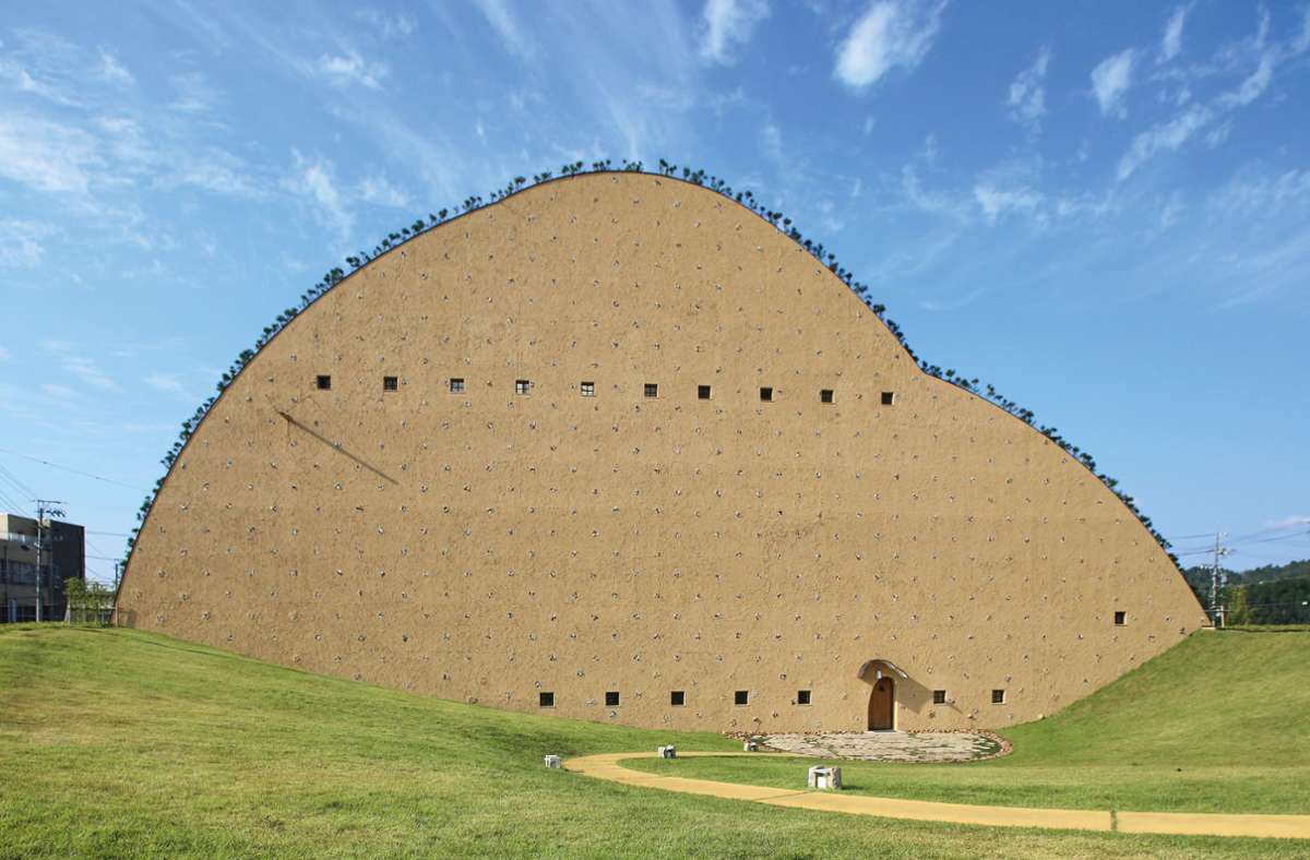 Mosaikfliesenmuseum aus dem Jahr 2016 von Terunobu Fujimori in Kasahara, Japan. Fliesen bestehen aus Erdmaterialien, also hat das Museum die Anmutung eines Erdhügels, sagt  Architekt Terunobu Fujimori. Die Konturen des Gebäudes werden durch Kiefernpflanzen begrenzt.