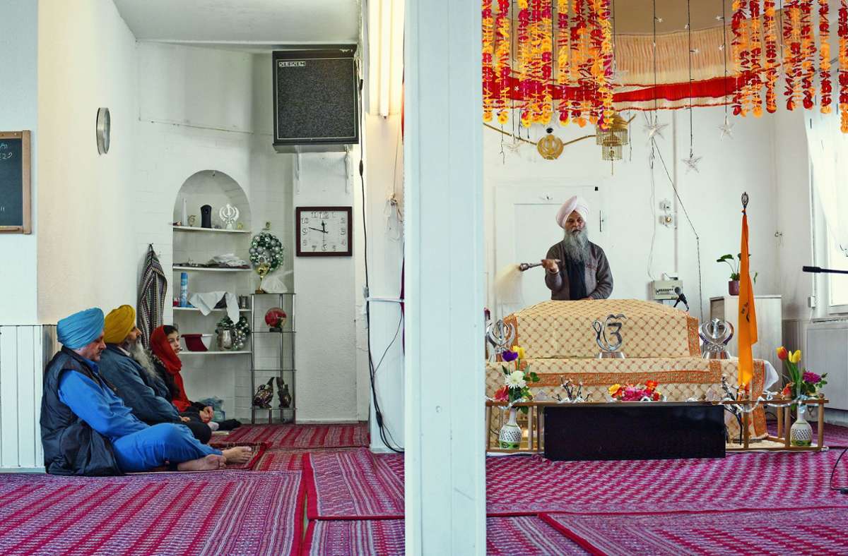 Ein Blick in das religiöse  Leben  der Sikhs: Der  Granthi mit weißem Turban  singt aus der heiligen Schrift.