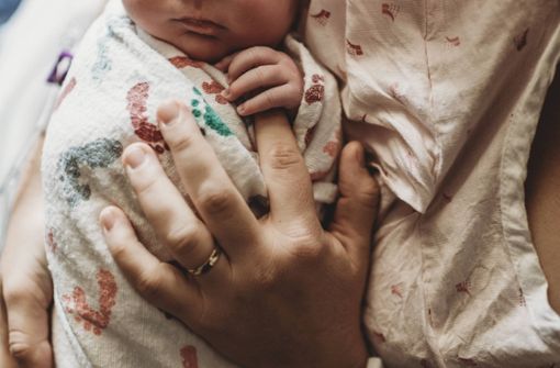 Ein Baby liegt wohlbehütet im Arm: Bei Schwangeren herrscht Unsicherheit über ein Medikament zur Geburtseinleitung. Foto: imago images/Cavan Images/Kelsey Smith