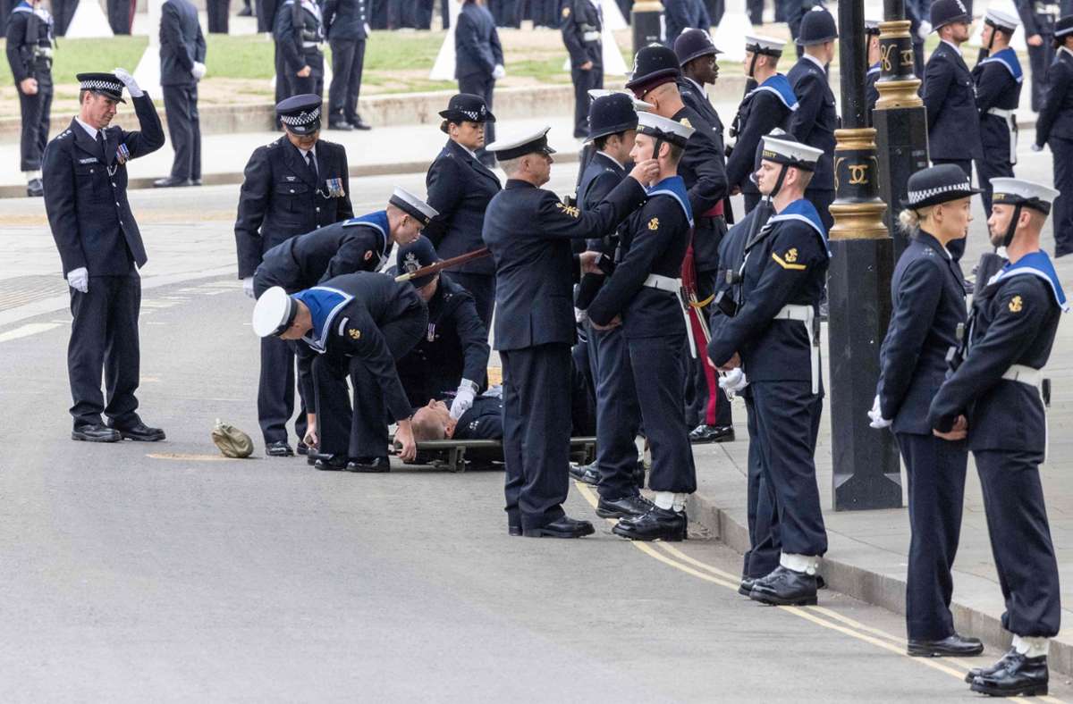 An der Westminster Abbey in London: Ein Polizist bricht vor Erschöpfung  zusammen. Foto: AFP/ROWAN GRIFFITHS