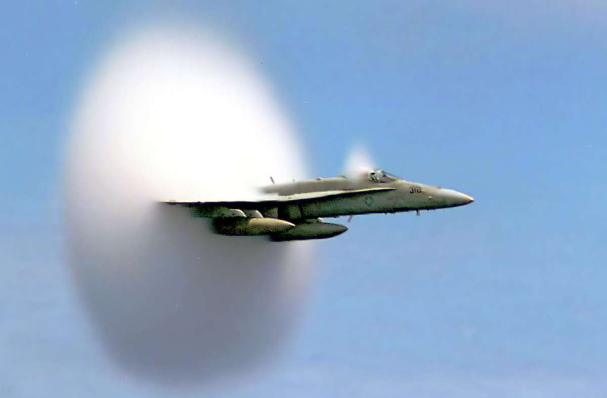 Ein Jagdbomber vom Typ F/A-18 Hornet der US-Navy beim Durchbrechen der Schallmauere:  Man sieht den Wolkenscheibeneffekt. Die Schallgeschwindigkeit in trockener Luft von 20 Grad Celsius  343,2 Meter pro Sekunde (m/s) – also 1236 Kilometer pro Stunde (km/h). Foto: Wikipedia commons/Ensign John Gay, U.S. Navy