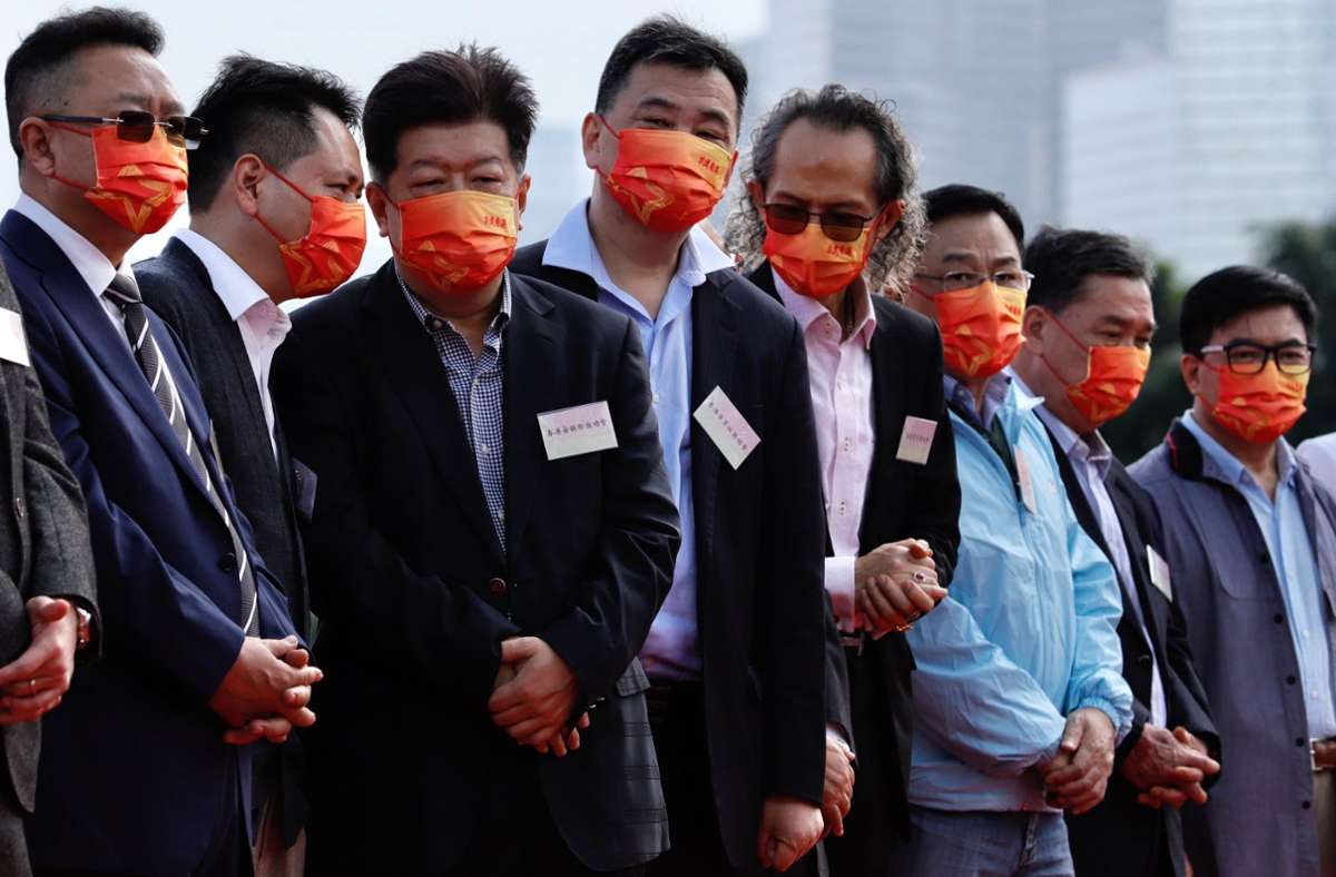 Mitglieder des Pro-Peking-Lagers tragen rote Mund-Nasen-Bedeckungen für die Treue zur Kommunistischen Partei. Foto: dpa/Liau Chung-Ren
