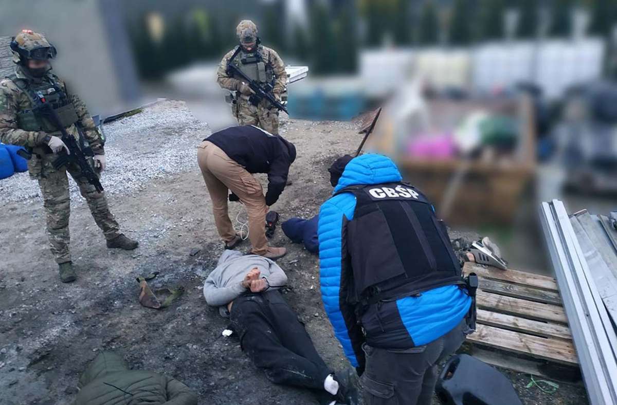 Polizisten durchsuchen Personen, die mit Handfesseln am Boden liegen. Die Polizei in Brandenburg und Polen hat eine Bande von sogenannten Planenschlitzern gefasst, die in drei Bundesländern aktiv war. Foto: dpa
