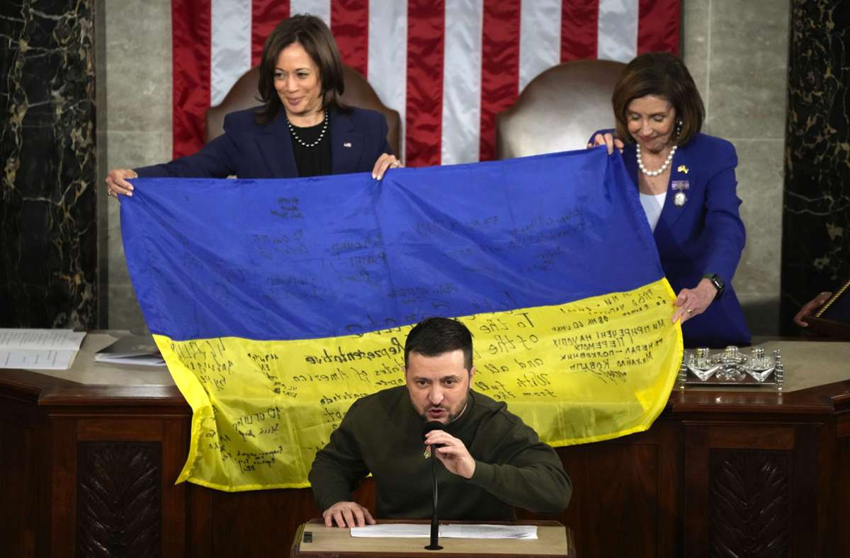Vizepräsidentin Kamala Harris (l.) und Nancy Pelosi, Sprecherin des Repräsentantenhauses, halten bei der Rede Selenskyjs eine ukrainische Flagge, die  Soldaten  signiert haben. Foto: dpa/Jacquelyn Martin