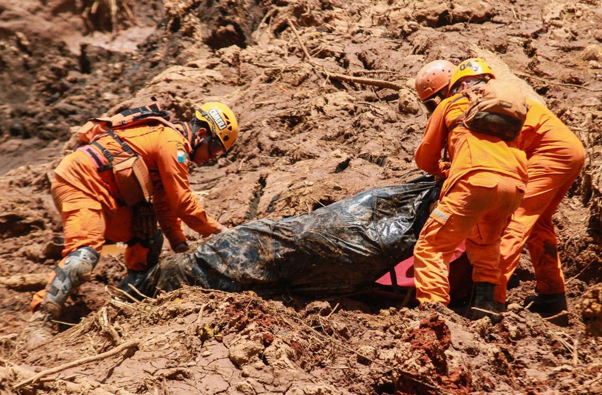 Rettungskräfte bargen ein Opfer aus dem Schlamm nach dem Dammbruch (Archivbild). Foto: Rodney Costa/dpa/Rodney Costa