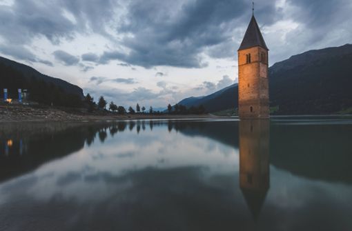 Südtirol-Touristen kennen den Reschensee mit seinem markanten, versunkenen Kirchturm. Foto: imago images/UIG